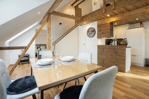 Ein Essbereich mit Holztisch, Stühlen und einer Uhr an der Wand.