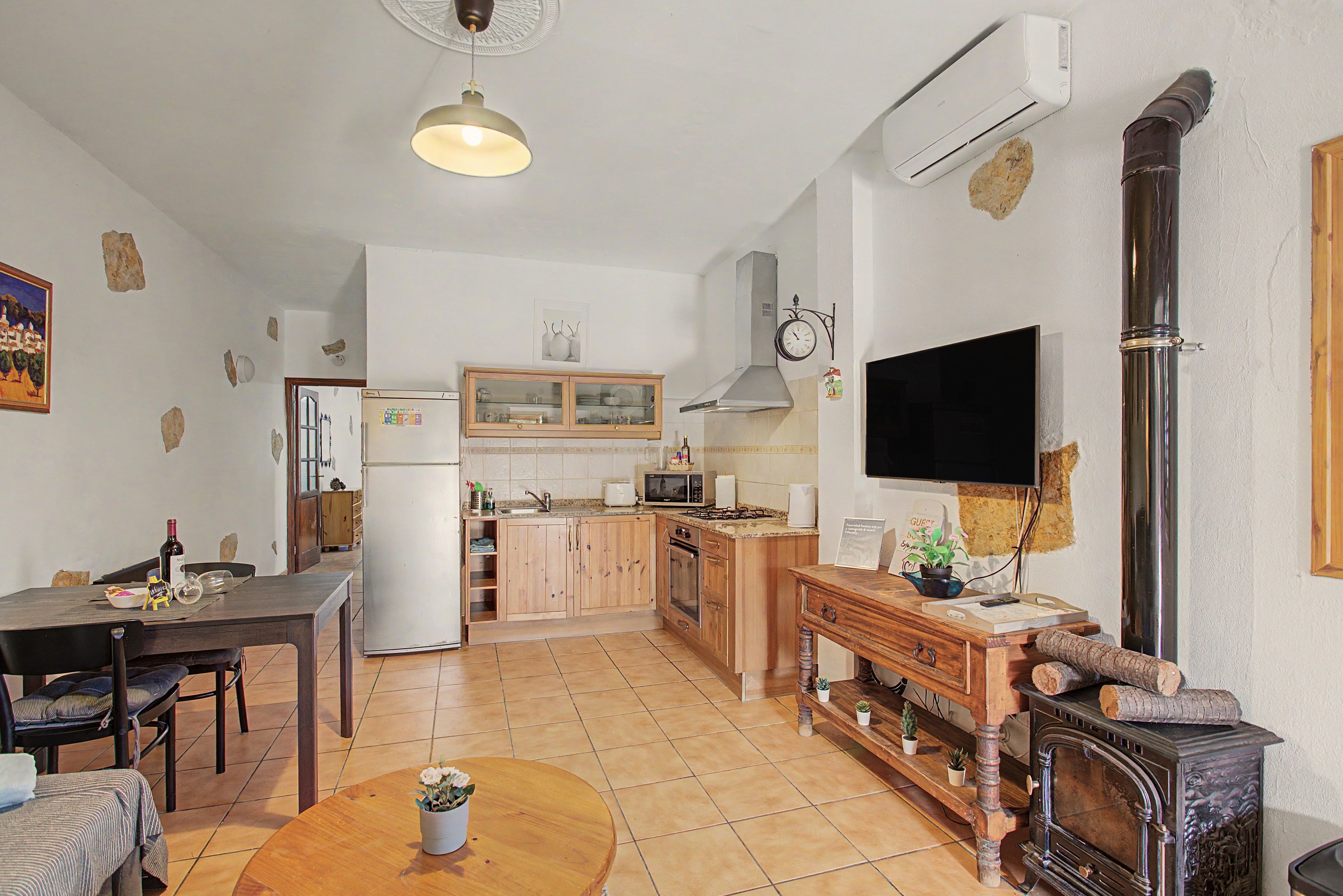 A compact living space with a dining area, kitchen, and a fireplace.