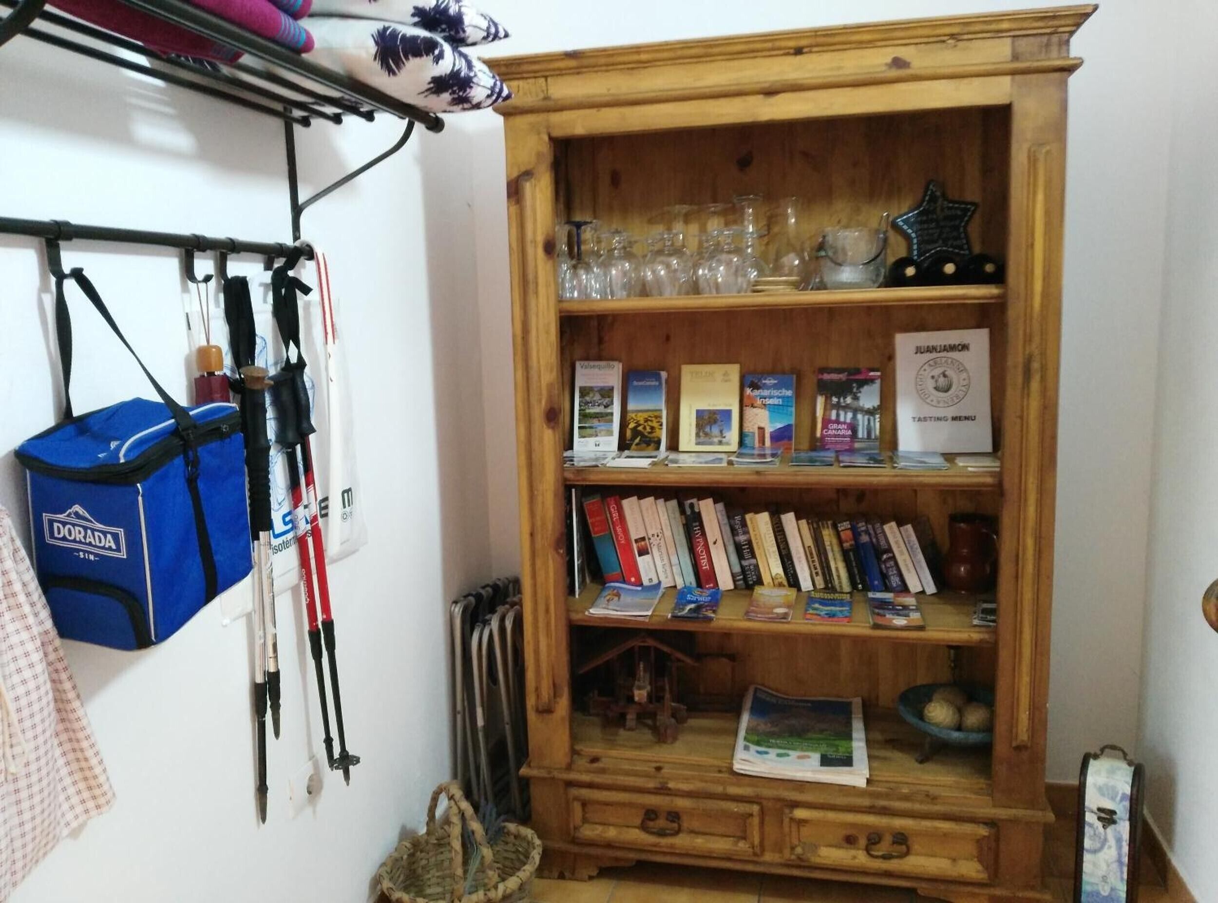 A wooden cabinet with books, a map, and a glass jar.