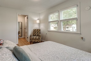 A bedroom with a bed, a chair, a window, and a door leading to another room. - Quiet Dayton Monthly Retreat, Near Hospitals (Dayton)