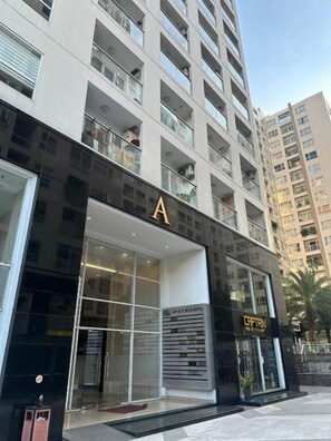 A modern building with a prominent 'A' sign, indicating an office building. - Teddy Apartment (Ho Chi Minh City)