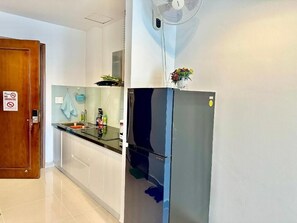 A modern kitchen with a stainless steel refrigerator, a wall-mounted fan, and a 'No Smoking' sign. - Teddy Apartment (Ho Chi Minh City)
