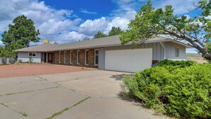 Ein eingeschossiges Haus mit Garage, einer Veranda und einer Auffahrt.