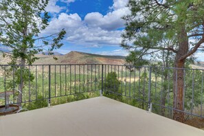 Ein Balkon mit Metallgeländer mit Blick auf eine gebirgige Landschaft mit spärlicher Vegetation.