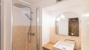 A bathroom with a glass shower enclosure, a white sink, and a mirror with a decorative frame. - Studio with views of the ski slopes and a mountain-themed area (Allos)