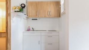 A compact kitchen with white cabinets, a sink, and a small countertop. - Studio with views of the ski slopes and a mountain-themed area (Allos)