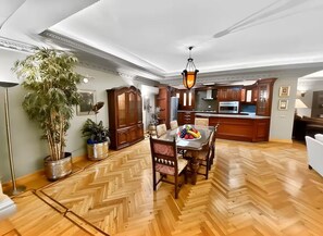 Una cocina amplia con armarios de madera, una mesa de comedor con sillas y una araña.