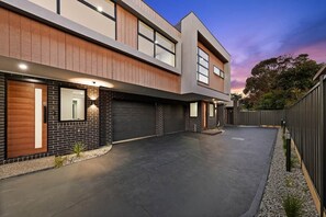 A modern two-story house with a driveway, a garage, and a fenced backyard. - Modern Luxury Living House (Fawkner)