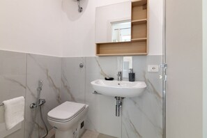 Ein Badezimmer mit Toilette, Waschbecken und Dusche.