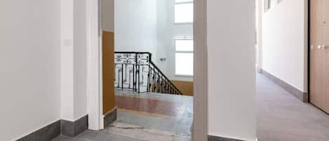 Ein Flur, der zu einer Treppe mit Metallgeländer führt.