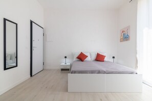 Une chambre à coucher au style minimaliste, avec un lit, des tables de chevet et une porte.