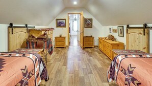 Una camera da letto con due letti, mobili in legno e un corridoio che porta a una porta.