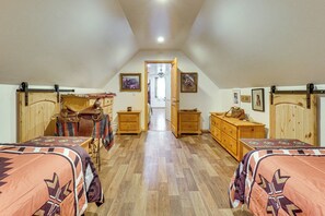 Ein Schlafzimmer mit zwei Betten, Holzmöbeln und einem Flur, der zu einer Tür führt.