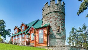 Una baita di legno con una torre e un tetto verde.