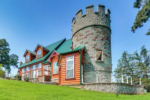 Eine Blockhütte mit einem Turm und einem grünen Dach.