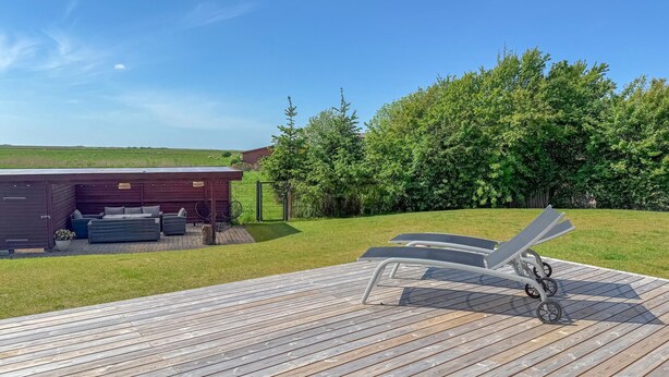A wooden deck with lounge chairs and a covered seating area with cushions. - Cozy home in Højer with WiFi (Højer)