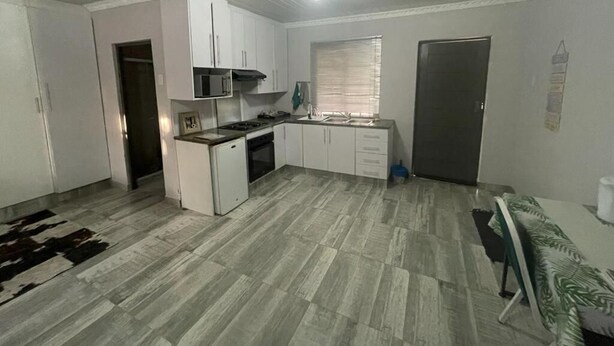 A compact kitchen with white cabinets, a microwave, and a stove.