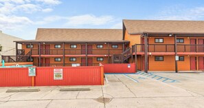 A multi-story building with a parking lot, marked with a wheelchair-accessible sign. - PCB Beach Home with Gulf Access, Pool, and more (Panama City Beach)