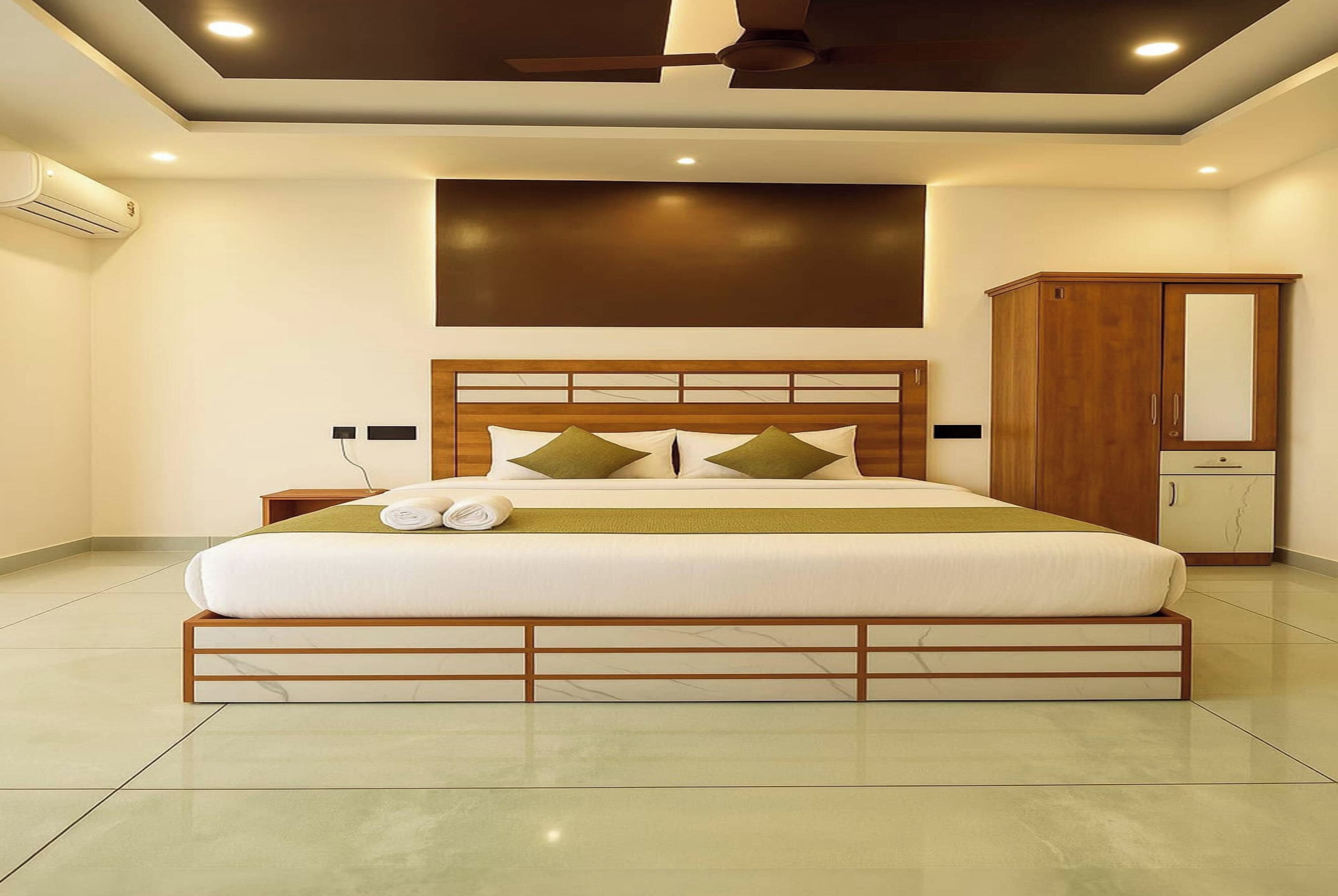 A modern bedroom with a large bed, wooden headboard, and a wardrobe.