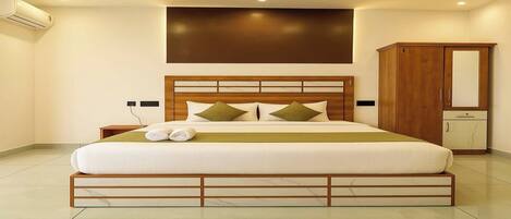 A modern bedroom with a large bed, wooden headboard, and a wardrobe.