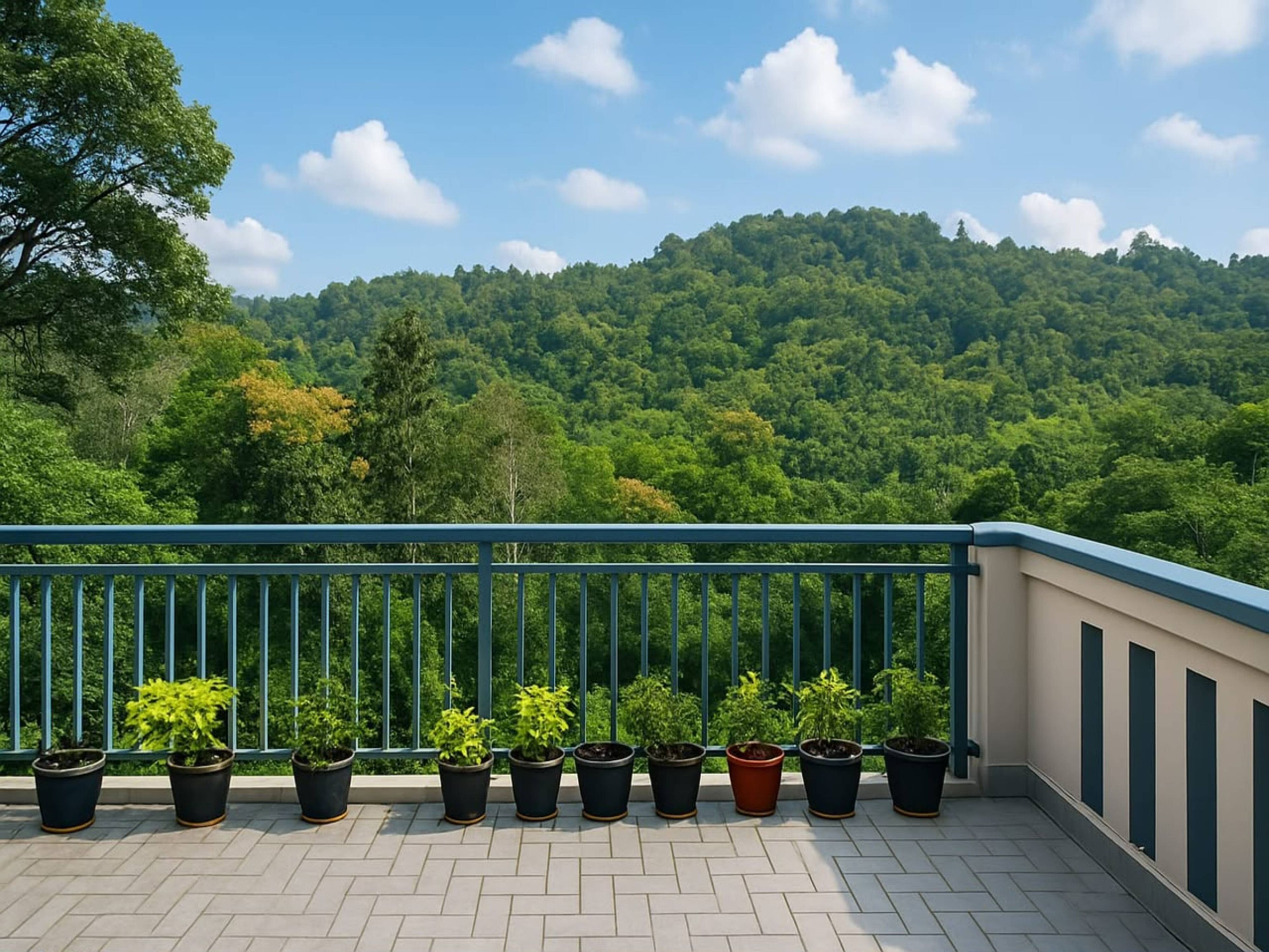 A balcony with potted plants and a view of a forested hill.