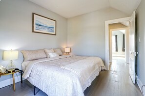 A bedroom with a bed, bedside lamps, a framed picture on the wall, and a door leading to another room. - Bay Views + Stargazing! Spacious Mount Vernon Home (Mount Vernon)