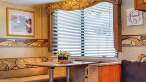 Un interior acogedor con un sofá, una mesita con una planta y una ventana con persianas.
