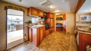 Una cocina compacta para autocaravana con armarios de madera, estufa y lavabo.