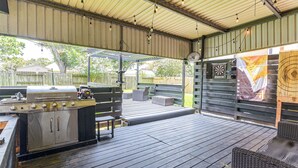 An outdoor patio with a barbecue grill, seating area, and a fan. - Games & Yard! Family Home Near Kemah Boardwalk (Dickinson)