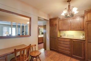 A wooden dining area with a chair, a table, and a mirror on the wall. - 4 Mi to Dtwn Wichita! 'Else House' w/ Yard & Patio (Wichita)