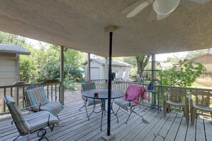 A covered outdoor deck with metal-framed chairs and a table, surrounded by a wooden deck and a view of residential buildings. - 4 Mi to Dtwn Wichita! 'Else House' w/ Yard & Patio (Wichita)