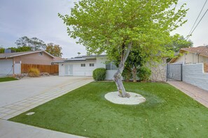 A residential property with a well-maintained lawn, a tree, and a garage. - Grill & Fire Pit! Palm Desert Extended Escape (Palm Desert)