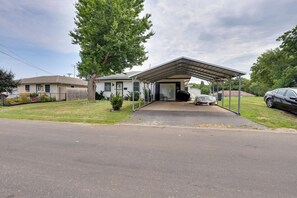 A single-story house with a covered porch, a fenced yard, and a parked car.