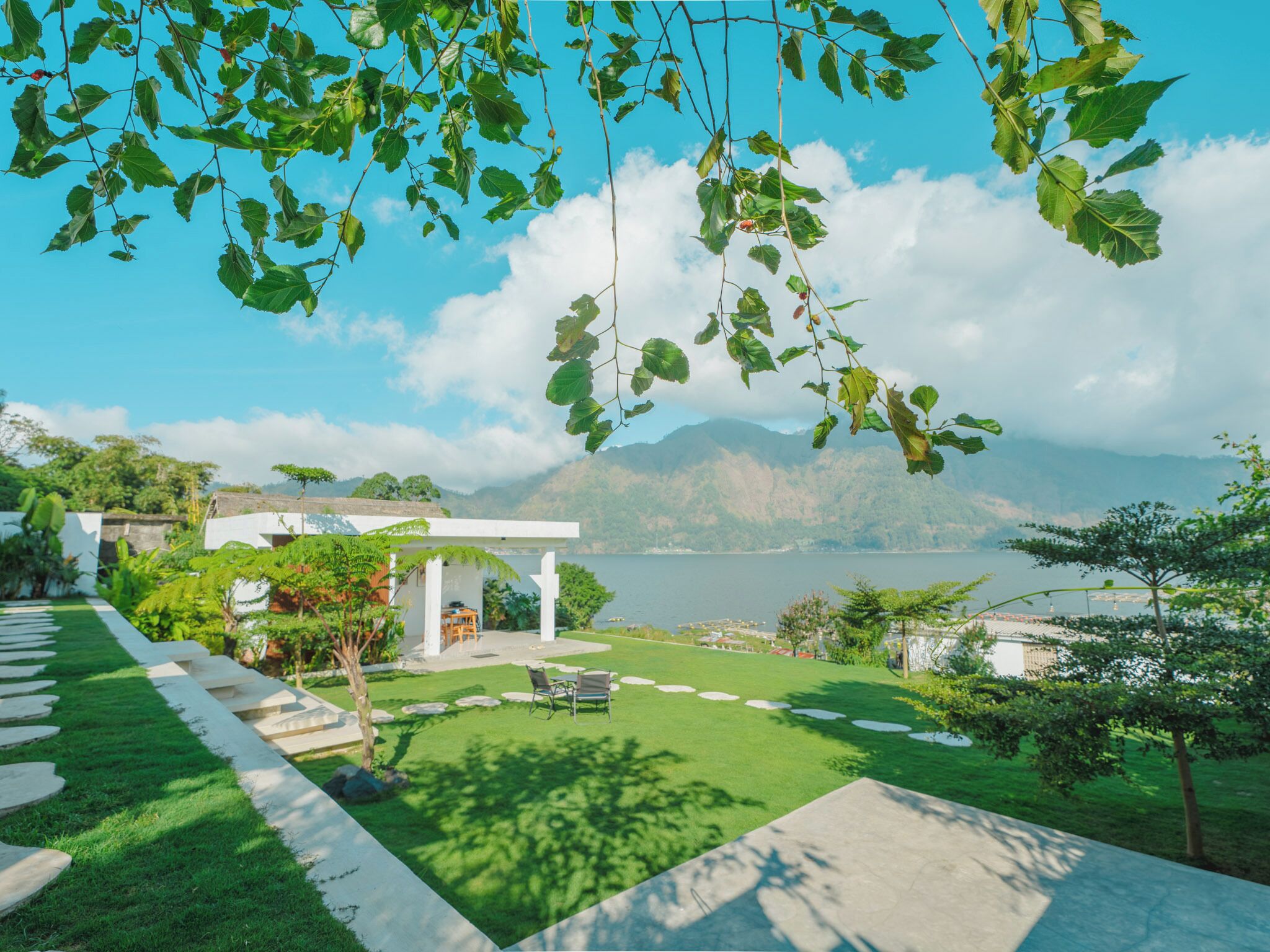 A modern outdoor area with a clear view of a lake and mountains in the background.