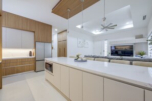 A modern kitchen with a central island, built-in appliances, and a ceiling fan. - Modern McAllen Townhome: 4 Mi to Dtwn (McAllen)