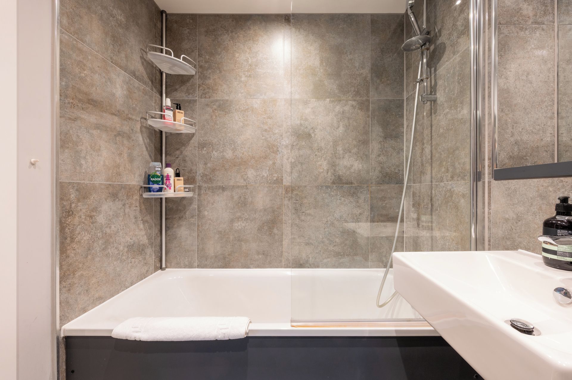 Ein modernes Badezimmer mit einer Badewanne, einer Dusche und einem Duschbereich mit Glastrennwand.