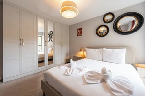 Ein Hotelzimmer mit einem Bett, einem Kleiderschrank, einem Nachttisch und einer Wand mit drei Spiegeln.