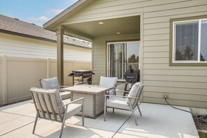 An outdoor patio with a table and chairs, a grill, and a covered area with a window. - 3 Mi to Spokane River! Furnished Patio & Yard (Post Falls)