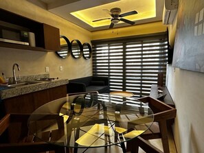 A modern kitchen with a glass dining table, built-in appliances, and a ceiling fan. - Condominium in Tulum, Mexico (Tulum)