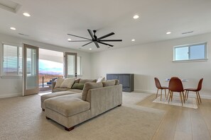 A spacious living room with a sectional sofa, a dining area with chairs, and a ceiling fan. - Resort-Style St George Casita w/ Lagoon Access (St. George)