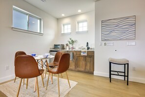 Eine moderne Küche mit Essbereich, Holzschränken und einem kleinen Hocker.