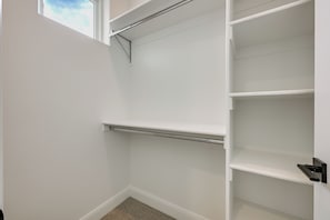 A white closet with open shelves and a metal rod. - Resort-Style St George Casita w/ Lagoon Access (St. George)