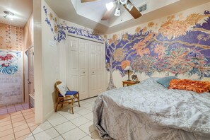 Een slaapkamer met een groot bed, een kledingkast, een stoel en een decoratief behang.