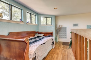 Ein Zimmer mit einem hölzernen Bett, einem Fenster und einer Heizung.