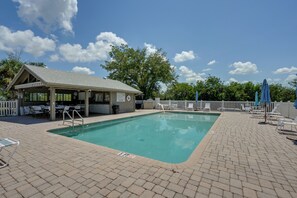 A pool area with a covered seating area, lounge chairs, and a lifeguard station. - Walk to the Gulf Coast! 55+ Retreat w/ Pool Access (Englewood)