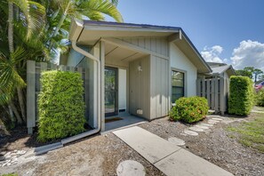 A residential property with a covered porch, a front door, and a small garden area with shrubs and a stepping stone path. - Walk to the Gulf Coast! 55+ Retreat w/ Pool Access (Englewood)