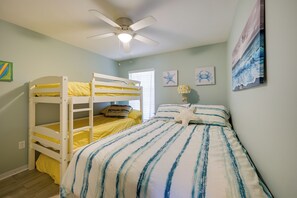 A room with bunk beds, a ceiling fan, and wall art. - Walk to the Gulf Coast! 55+ Retreat w/ Pool Access (Englewood)