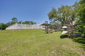 A grassy area with a white fence and numbered wooden posts, likely part of a park or recreational area. - Walk to the Gulf Coast! 55+ Retreat w/ Pool Access (Englewood)