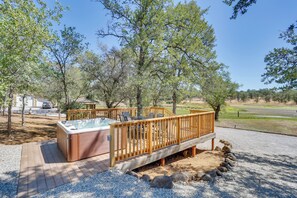 Een hottub op een houten terras met uitzicht op een natuurlandschap.