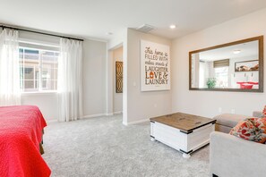 Un dormitorio con cama, cómoda, espejo y una pared con una frase motivacional.